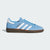 Blue Adidas sneaker with white stripes on a light gray background