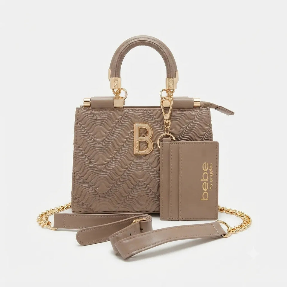 A taupe leather handbag with a wavy embossed pattern, gold-tone hardware, a top handle, a detachable shoulder strap, and a matching card holder pouch. The brand name 'bebe of paris' is printed in gold on the pouch.