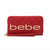 Red zip-around wallet with a wristlet strap, featuring a dark red monogram pattern and large gold 'bebe' lettering on the front, shown on a white background.