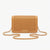 A tan woven leather crossbody bag with a gold-tone chain strap and a small 'bebe' logo plaque on the front, set against a plain white background.