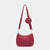 A burgundy studded crossbody bag with a matching round coin purse and adjustable shoulder strap, displayed on a light gray background.