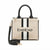 A structured beige tote bag with black leather handles and trim, featuring a vertical black and white stripe design and the brand name 'bebe' printed in black across the front. A detachable black shoulder strap with gold-tone hardware is coiled in front on a white background.