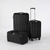 Three-piece black hardshell luggage set including a carry-on, a medium suitcase with telescoping handle extended, and a duffel bag, photographed on a light gray studio background.