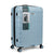 A light blue hard-shell suitcase with vertical grooves, four spinner wheels, and a telescoping handle, shown on a white background with its retail packaging label still attached.