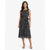 A woman modeling a sleeveless black midi dress with a white polka dot pattern and a matching fabric tie belt at the waist, set against a plain light gray studio background.