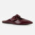 A single burgundy patent leather mule slipper with a pointed toe and a decorative bow detail on the upper, shown against a plain white background.