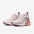 A pair of Nike Air Max 270 sneakers in a light pink and rose gold colorway, featuring a textured mesh upper, white midsoles, and translucent pink air units.