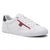 A white leather low-top sneaker with a red side stripe, a red embroidered Tommy Hilfiger logo patch, white laces, and a dark navy heel tab, shown on a white background.