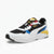 A Puma sneaker in white, black, blue, red, and yellow, shown from a three-quarters angle on a light gray background.