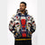 A man wearing a pullover hoodie with a complex, colorful graphic print featuring stylized faces, geometric shapes, and bold blocks of red, navy, yellow, white, and black, set against a plain light gray background.