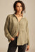 Woman wearing a green patterned shirt against a beige background