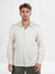 Man wearing a light-colored button-up shirt against a white background