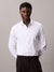 Man wearing a white dress shirt and black pants against a plain background