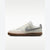 A Nike low-top sneaker in off-white leather with a light gray Swoosh, a light pink suede toe overlay, and a brown gum sole, shown against a plain white background.