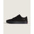 A black low-top Vans sneaker shown from the side against a light beige background.
