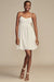Woman wearing a white lace dress against a beige background