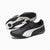 A pair of Puma sneakers in black, white, and red, with one shoe showing the side profile and the other showing the sole.