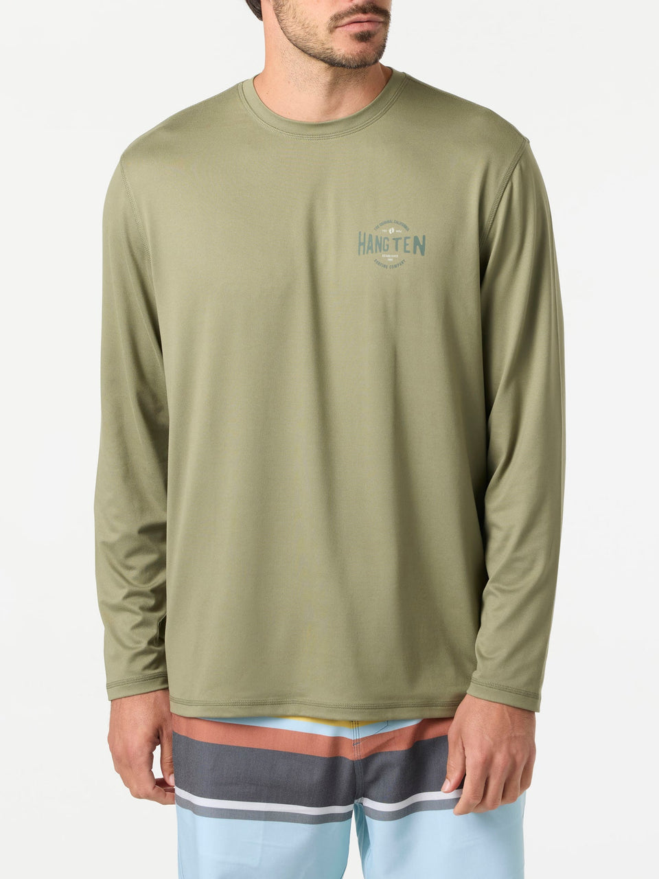 Man wearing a green long-sleeve shirt with a logo on a white background