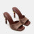 Pair of brown high-heeled shoes with textured design on a white background