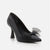 A single black leather high-heeled pump with a pointed toe and a sheer black tulle bow detail on the front, shown against a light gray background.