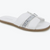 A white slide sandal with textured straps, a silver patterned center stripe, and a brown gum sole, shown on a plain white background.