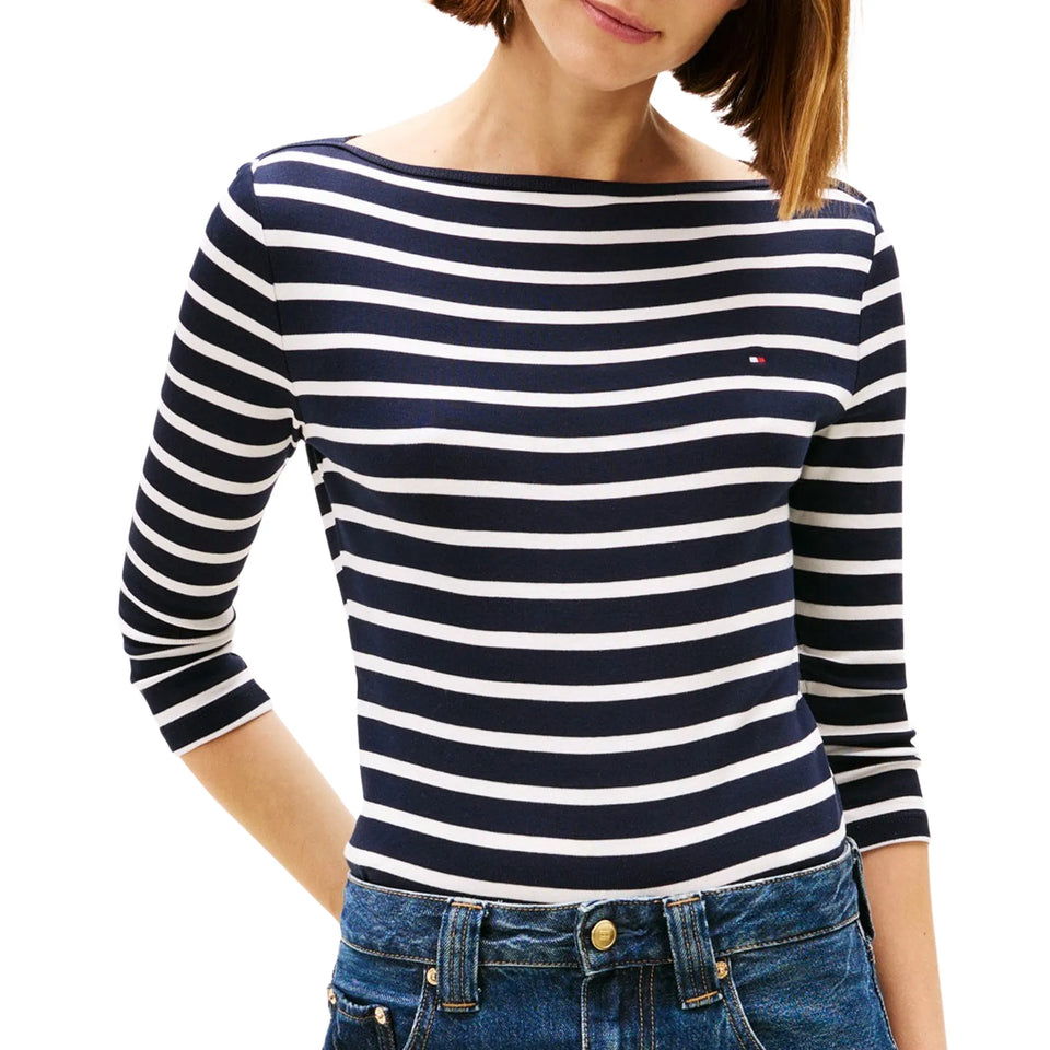 Woman wearing a navy and white striped long-sleeve shirt with a brand logo.