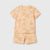A two-piece kids' pajama set featuring a short-sleeve top and matching shorts in a light peach color with an orange palm tree pattern, displayed flat against a light gray background.
