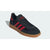 Black Adidas sneaker with red stripes on a white background