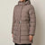 A woman wearing a mid-length taupe puffer coat with a hood, zippered front, and a matching elasticated belt with a silver buckle, shown against a plain light gray background.
