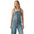 A woman modeling a light blue denim jumpsuit with a structured corset-style bodice, front zipper, and wide legs, photographed against a plain white background.