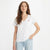 A woman modeling a white short-sleeve V-neck t-shirt with a small red Levi's logo on the left chest, paired with light blue jeans against a plain white background.