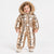 A toddler wearing a shiny metallic gold puffer snowsuit with a faux-fur trimmed hood, standing against a plain light gray studio background.