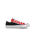 A low-top canvas sneaker in black and red, featuring white laces, a white rubber toe cap, and a white midsole with a black stripe, shown against a plain white background.