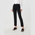 A model wearing black ankle-length straight-leg trousers, styled with a white long-sleeve blouse and black slide sandals, photographed against a light gray studio background.