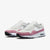 A pair of Nike Air Max 2013 sneakers in white and dusty pink, featuring a white mesh upper, pink suede overlays, a white Swoosh, and a white midsole with a visible air cushion unit.