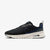 A Nike sneaker in black and navy blue with a white midsole, shown from the side against a light gray background.