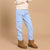 A child wearing light blue cargo jogger pants with elastic cuffs, styled with a cream sweatshirt and brown suede ankle boots against a solid beige studio background.