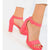 A pair of women's bright pink block-heel sandals with ankle straps and open toes, shown on a model's feet against a clean white background.