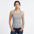 A woman modeling a heather gray racerback tank top with dark blue jeans, standing against a plain white studio background.