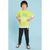 A young boy modeling a bright lime green graphic t-shirt with white and green details, paired with black sweatpants and a black beanie, standing against a light blue background.