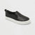 Black slip-on sneaker with glittery texture on a light gray background