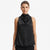 A woman modeling a sleeveless black cowl-neck top with a draped, gathered neckline against a plain light gray studio background.
