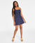 Woman wearing a navy blue dress with white patterns on a white background