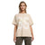 A woman modeling an oversized beige t-shirt with a large white distressed graphic on the front, paired with leopard-print pants, against a plain white background.