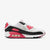 A Nike Air Max 90 sneaker in white, black, and bright pink, shown from a side profile view against a light gray background.