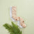 Three pairs of socks arranged on a pale green background with a green fern leaf at the bottom left. The socks include two solid light gray pairs and one tan pair with a small fox print.