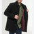 A man wearing a black wool-blend coat with a dark burgundy quilted lining, shown from the chest down against a light gray studio background.