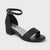 Black sandal with block heel on a light gray background