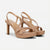 A pair of women's platform slingback sandals in a light tan leather, featuring criss-cross front straps, a high stiletto heel, and an adjustable ankle strap, shown against a plain white background.