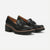 A pair of black leather platform loafers with chunky lug soles and decorative metal hardware on the vamp, shown against a light gray background.